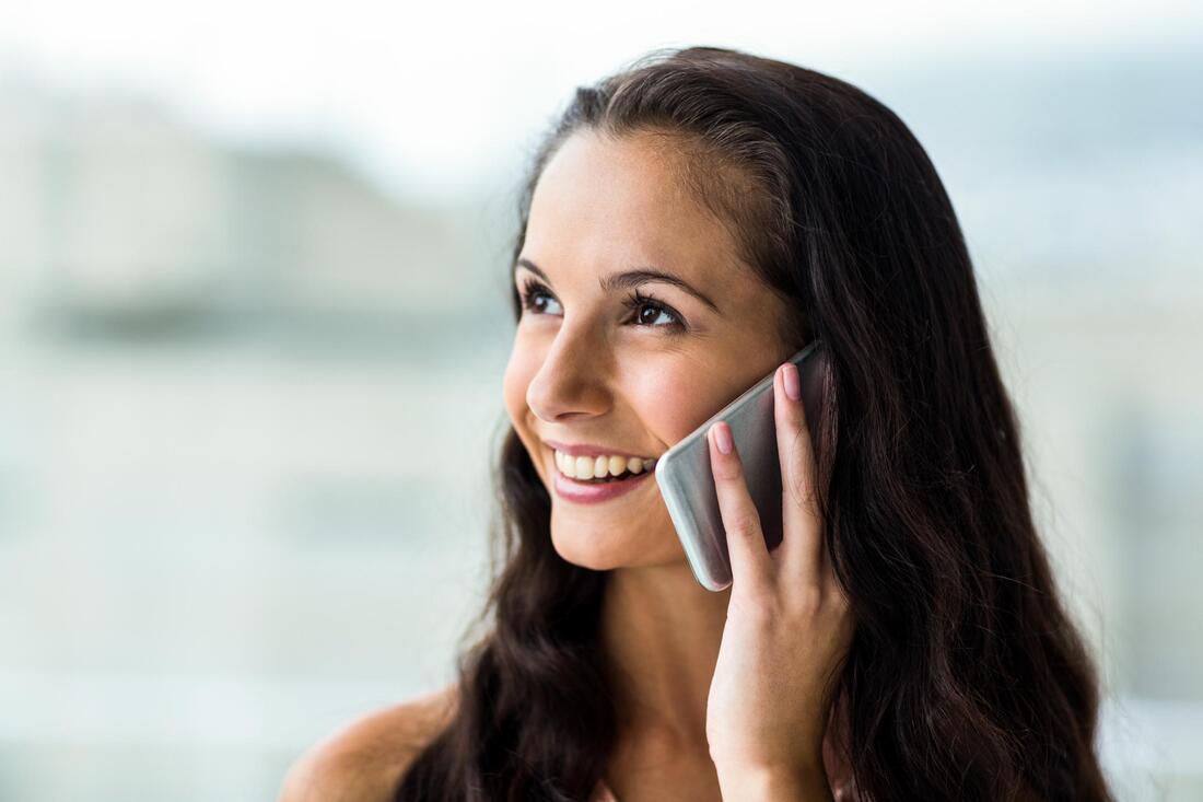 a lady happily talking on the phone 